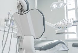 A white dental chair in a room with a window